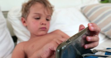 Closeup toddler using smartphone device at home, child touching screen