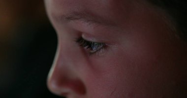 Çocuk gözleri tablette oyun oynarken yakın çekim. Ekranı izleyen oğlanın yakın çekimi