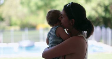 Candid mother holding baby infant interaction caring and loving