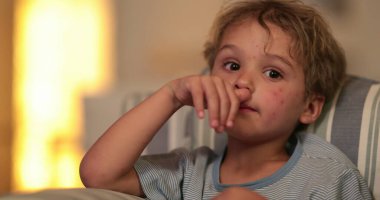 Child boy face watching TV on sofa at night before bed