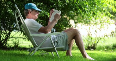 Man reading book story outside in nature