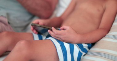 Child toddler boy playing game on cellphone device