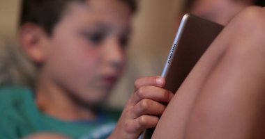 Tablet cihaz teknolojisi kullanan çocuk, geceleri video oyunu oynayan gizli çocuk.