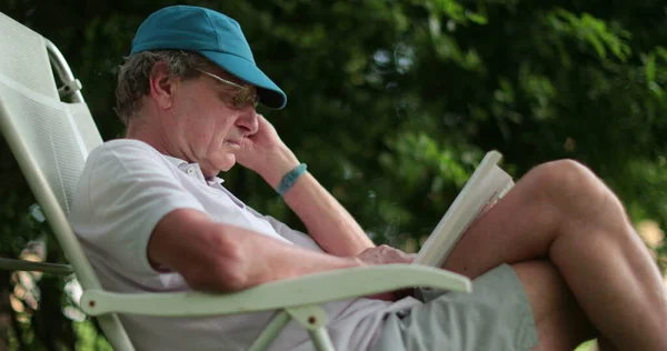 Elderly Man Reading Book Outdoors Person 70S Enjoying Retirement — Zdjęcie stockowe