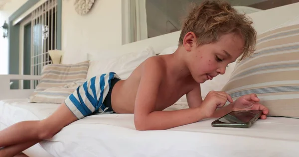 Випадковий Маленький Хлопчик Дитина Використовує Мобільний Телефон Лежачи Дивані — стокове фото