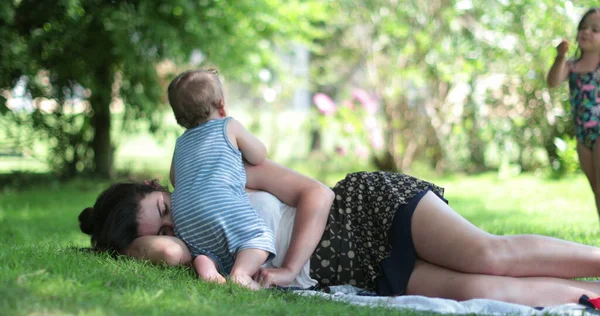 休憩をしたい疲れ切った母親 裏庭で屋外で休んでいる親 — ストック写真