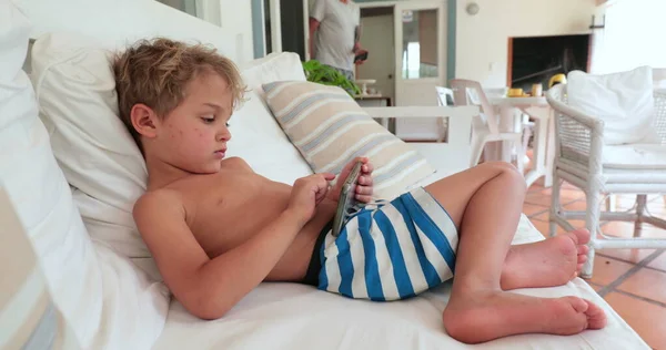 Child Lying Sofa Playing Video Game Smartphone Device Casual Candid — Zdjęcie stockowe