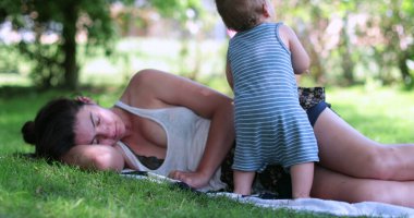 Bitkin düşmüş anne çimenlerde yatıyor.