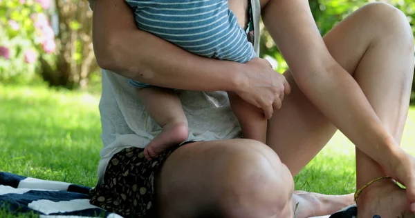 stock image Mother hugging and holding baby outside in park