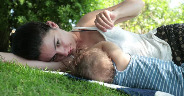 stock image Mother lying on grass with baby child