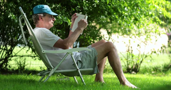 Senior Man Reading Book Outdoors Casual Candid Older Retired Man — Stockfoto