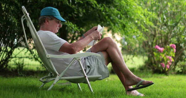 Older Retired Man Reading Book Outdoors Senior Man Reading Novel — Zdjęcie stockowe