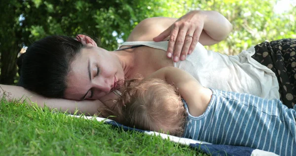 stock image Mother lying on grass with baby child