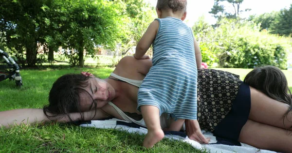 Mother Sleeping Grass Toddler Infant Wanting Attention Parent Taking Break — Φωτογραφία Αρχείου