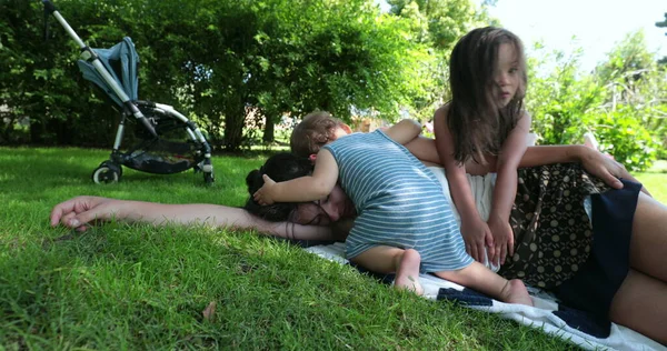 妈妈想睡在外面的草地上 妈妈从婴儿身上休息 婴儿需要注意 — 图库照片