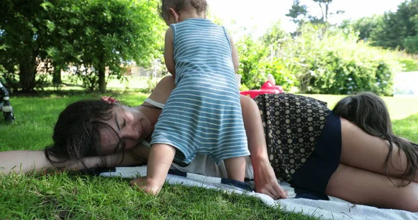 Mother Sleeping Grass Toddler Infant Wanting Attention Parent Taking Break — Zdjęcie stockowe