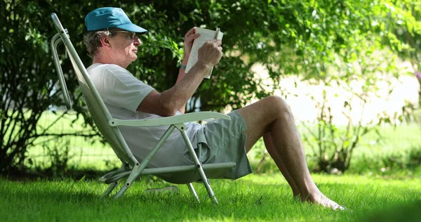 Senior Man Reading Book Outdoors Casual Candid Older Retired Man — Stockfoto