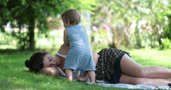 Tired Mother Trying Sleep Laid Grass Baby Wanting Mom Attention — Stock Photo, Image