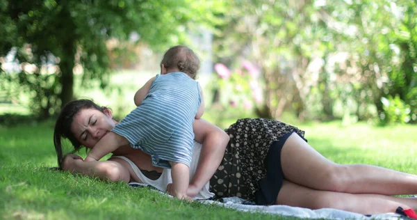 疲れて母親の外の草の上に置かれた睡眠しようとする ママの注意を望んでいる赤ちゃん 率直で本物 — ストック写真