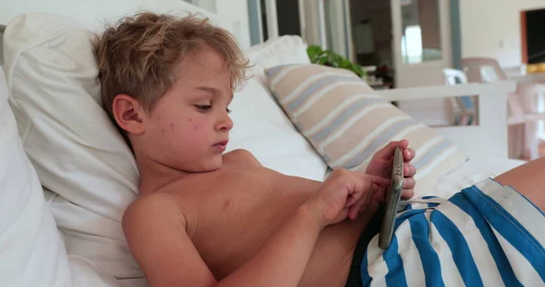 Młody Chłopiec Leżący Kanapie Pomocą Smartfona — Zdjęcie stockowe