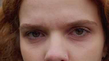 Duygularını değiştiren bir kadın, kameraya bakan makro-yakın gözler. Beyaz saçlı bir kadın ciddi ve endişeli oluyor.