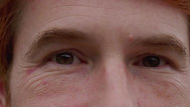 Kameraya bakan kızıl saçlı bir genç adamın Macro yakın çekimi. 30 'lu yaşlarda beyaz erkek.