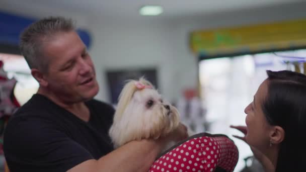 快乐宠物客户抱小狗 女业主在梳妆台后把什子交给男人 — 图库视频影像