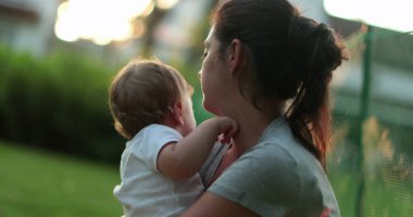 Anne dışarıdaki bebeğe mercekle bakıyor ve onu teselli ediyor.