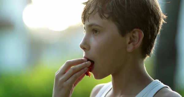 Menino Bonito Comendo Frutas Mastigando Enquanto Olha Para Câmera Sorrindo — Fotografia de Stock