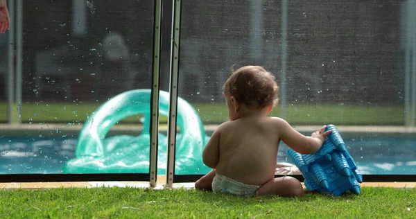 游泳池里的家人 前景中的婴儿和在水里玩背景游戏的孩子 — 图库照片