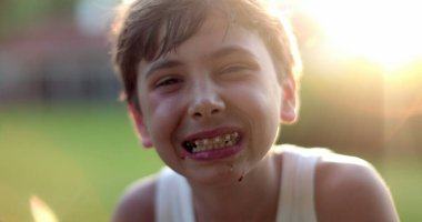 Dışarıda duran diş teli takan küçük bir çocuk.