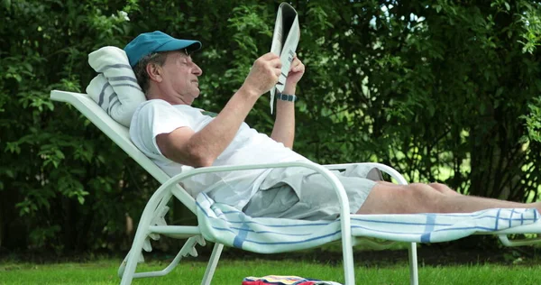 Candid Senior Man Reading Newspaper Outdoors — Stockfoto