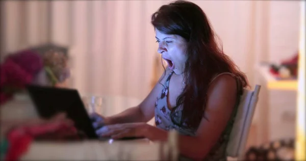 コンピュータのラップトップの前であくびをする女 — ストック写真