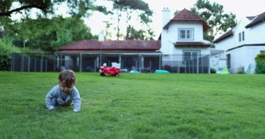 Evin arka bahçesinde tatlı bir bebek emekliyor.