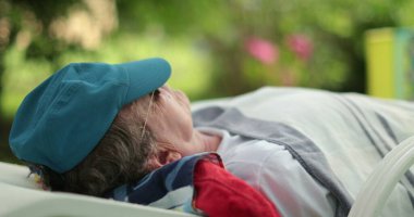 Man sleeping lying down outside. Older retired person napping outdoors