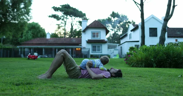 爸爸和宝宝一起躺在外面的草地上 — 图库照片