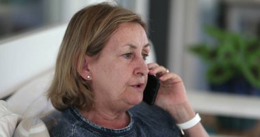 Older woman speaking on phone. Candid senior lady talking on smartphone