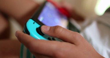 Çocuk yakın çekimde oyun oynuyor. Oyun çubuğunda çocuk parmağı