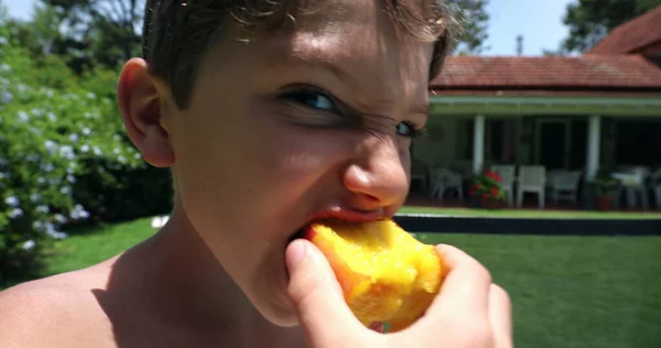 屋外で桃の実を食べる子供 若い男の子は夏の日の間に外で健康的な軽食を食べる — ストック写真