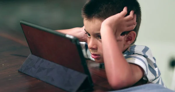 若い男の子がオンラインでタブレットコンテンツを見て吸収した 子供の腕時計映画 — ストック写真