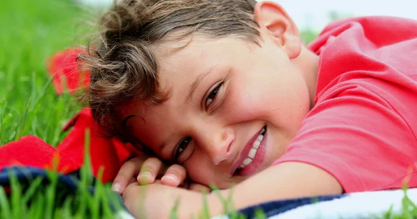 Красивий Молодий Хлопчик Посміхається Камери Покладеної Траву Зовні — стокове фото