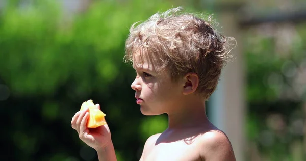 Snyggt Småbarn Som Håller Och Äter Gul Melonfrukt — Stockfoto