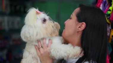 Küçük köpeğini kucaklayan mutlu kadın. Samimi bir köpek sevgisi ve Shih-Tzu cinsi ile ilgilenme anı.