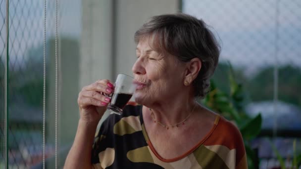Одна Задумчивая Пожилая Женщина Пьет Кофе Созерцая Вид Балкона Квартиры — стоковое видео