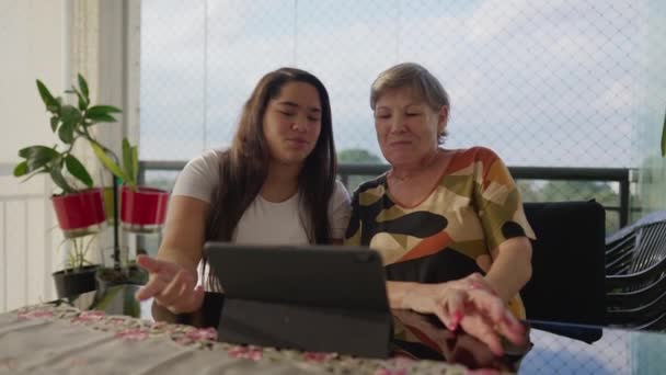 Vinculación Intergeneracional Nieta Diversa Asistir Abuela Caucásica Con Tablet Balcón — Vídeo de stock