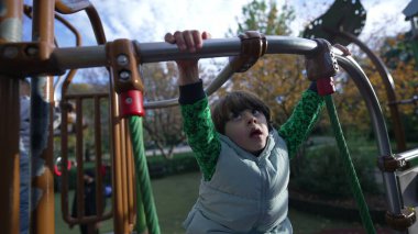 Çocuk dışarıdaki oyun parkına tırmanıyor. Aktif küçük çocuk dışarıda egzersiz yapıyor. Sportif çocuk.