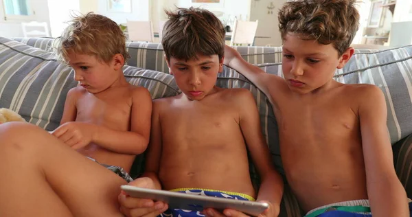 Gyermekek Előtt Tabletta Eszköz Otthoni Kanapén Gyerekek Testvérek Hipnotizált Képernyőn — Stock Fotó