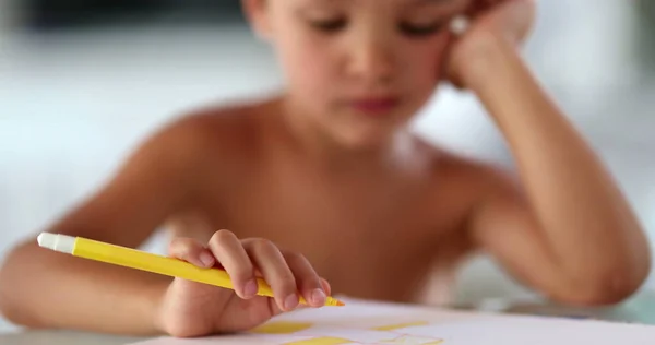 노란색 펜으로 종이에 그림을 그리는 어린이 — 스톡 사진