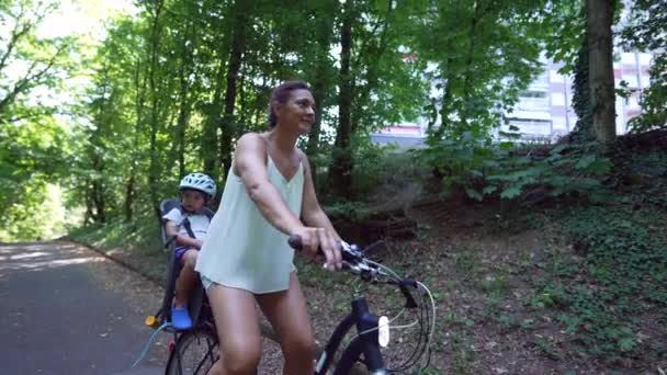 Мать Ездит Велосипеде Ребенком Велосипеде Сиденье Зеленой Дорожке Открытом Воздухе — стоковое видео