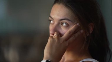 Contemplative woman thinking deeply at apartment balcony. Pensive female person in her 30s with thoughtful emotion. closeup face serious expression